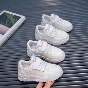 Macro view of four white children's fashion sneakers on a grey slatted surface