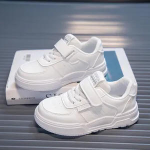 Detailed view of stylish white children's sneakers featuring velcro straps and lace-up design