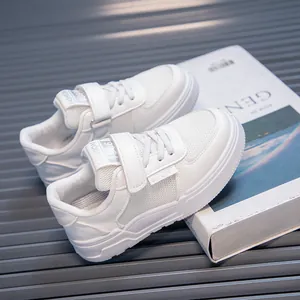 Detailed view of children's white sports shoes with breathable mesh and secure velcro straps
