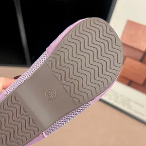Detailed macro view of the anti-slip wavy brown rubber outsole on a purple kids' sneaker