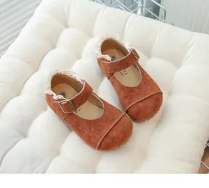 Detail shot of children's vintage brown suede shoes with lace trim and metal buckle
