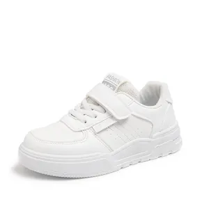 Side view of white kids sports shoe showing velcro strap and breathable lining