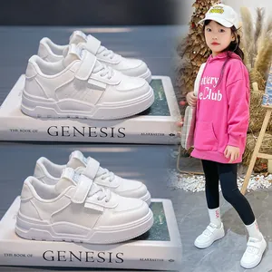 Detail view of children's white fashion sneakers with soft soles and velcro strap