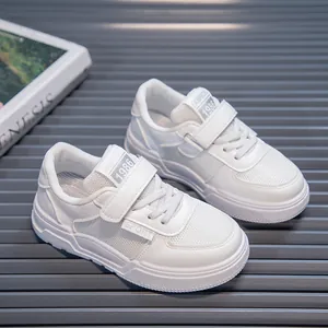 Close-up of white children's sports shoes featuring breathable mesh and velcro straps.