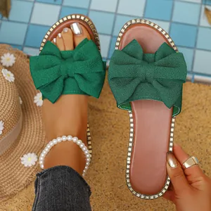Elegantes sandalias planas verdes para mujer con lazo grande y borde decorado
