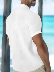 Back view of a white textured short-sleeved polo shirt for men in a tropical beach setting.