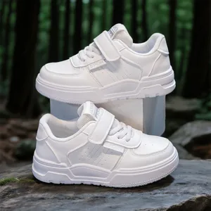 Stylish all-white children's sports shoes with velcro straps in forest setting