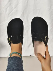 Gros plan détaillé de sabots rétro noirs avec boucle en métal et texture en daim doux