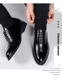 Dettaglio di scarpe Oxford in pelle nera lucida con punta classica a cappuccio e stringhe