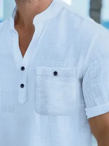 Detailed view of the white textured fabric and buttoned chest pocket on a men's polo shirt