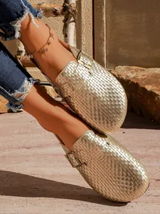 Vue détaillée des sabots à plateforme tressés dorés avec boucle métallique chic.