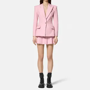 Giacca blazer rosa sartoriale con bottoni in ottone giapponese e gonna a pieghe.