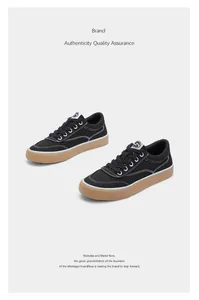 Nahaufnahme von schwarzen Low-Top-Canvas-Sneakern mit weißen Nähten und braunen Gummisohlen