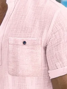 Close-up detail of pink textured fabric on a men's short-sleeved Polo shirt with pocket.