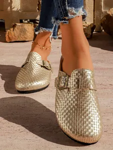 Détail des sabots à plateforme tressés dorés pour femmes avec boucle rétro chic