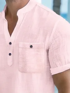Detailed close-up of a pink men's short-sleeved Henley shirt with textured fabric surface