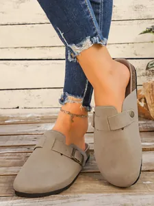 Détail de sabots à plateforme en daim gris avec une sangle à boucle réglable pour femme