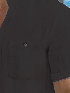 Detailed close-up showing the textured waffle fabric and chest pocket of a men's dark grey polo shirt