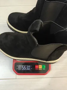 Medición detallada del peso de botas Chelsea negras en una báscula digital roja
