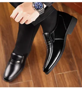 Dettaglio in primo piano di scarpe eleganti da uomo in pelle nera su suolo in legno