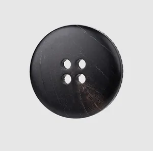 Detalle macro de un botón de cuerno negro de alta calidad con cuatro agujeros y textura
