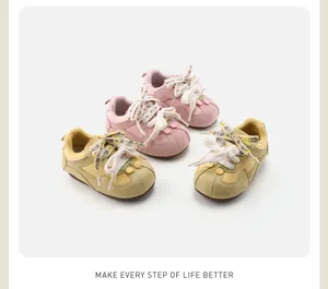 Vintage pastel pink and yellow baby toddler trainers with soft soles and floral laces.