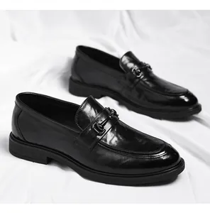Detailansicht schwarzer Herren-Loafer mit Metallschnalle auf weißem Stoffhintergrund