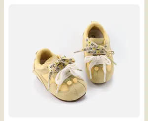 Detail of vintage yellow toddler walking shoes with floral laces and soft soles