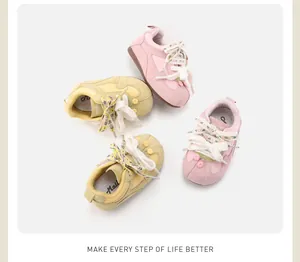 Detailed view of pink and yellow retro toddler walking shoes with floral laces on white background.