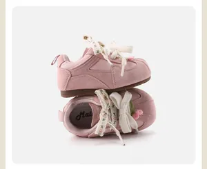 Detailed view of pink toddler shoes with floral lace and decorative bows