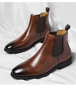 Classic brown leather Chelsea boots with a polished toe, displayed on white fabric.