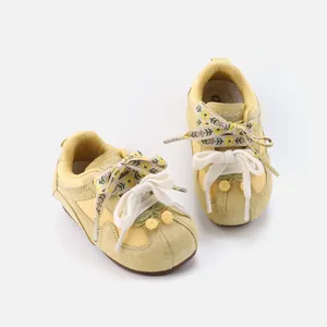 Vintage yellow baby walking shoes with floral laces and soft soles for toddler girls