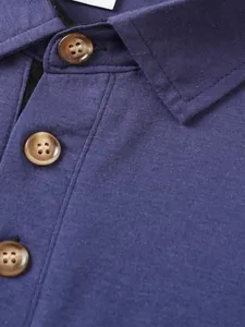 Detalle macro de polo para hombre con botones jaspeados marrones y textura de tela morada