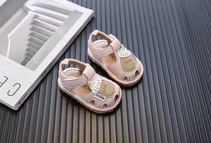 Detailaufnahme von rosa Baby-Lauflernsandale mit einem süßen Cartoon-Milchflaschendesign