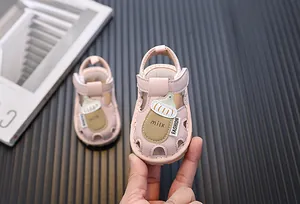 Detailansicht der rosa Baby-Sandalen mit einem niedlichen Cartoon-Milchflaschen-Motiv