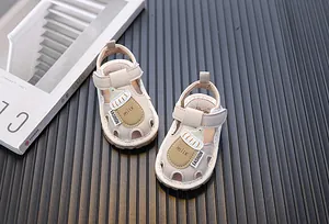 Detailansicht beige Babysandalen mit Milchflaschen-Motiv und weicher, rutschfester Sohle.