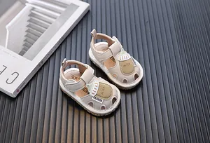 Nahaufnahme von beigen Babysandalen mit niedlichem Milchflaschen-Design und weicher Sohle
