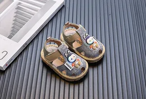Primer plano de sandalias infantiles con astronauta de dibujos y estampado oblicuo.