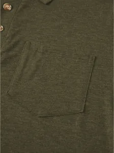 Vista detallada de un polo para hombre verde oliva con bolsillo y textura de tela.