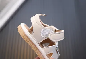 Detailansicht der Ferse einer beigen weichen Babysandale mit verstellbarem Klettverschluss
