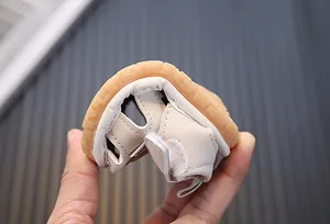 Detaillierte Nahaufnahme der flexiblen Gummisohle bei beigen weichen Baby-Sandalen für Kleinkinder.