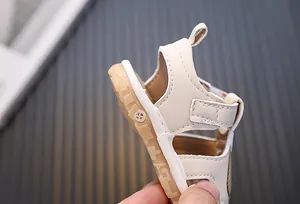 Makroaufnahme der weichen Gummisohle und der cremefarbenen Kunstlederferse der Kindersandale