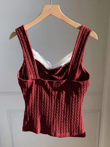Close-up view of a burgundy cable-knit tank top featuring delicate white lace trim