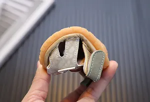 Primer plano de la suela de goma flexible en sandalias de bebé mostrando suavidad.