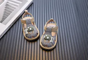 Vue détaillée de sandales pour bébé avec un motif champignon et brides grises