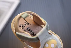 Gros plan de la semelle intérieure d'une sandale pour bébé avec le logo KAMENG.