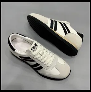 Baskets rétro en cuir blanc style German Army pour hommes avec rayures noires et semelle épaisse.