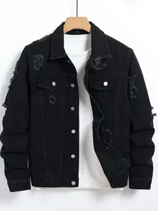 Detail of men's black distressed denim jacket with ripped holes and button closure