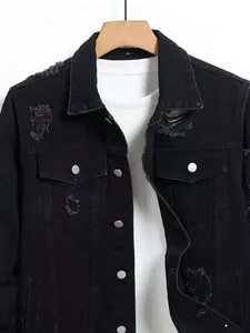 Close-up of men's black distressed denim jacket featuring ripped details and collar.
