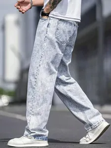 Side view detail of light blue snow-washed loose straight-leg denim jeans for men